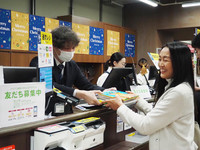 Accessories artist Runako Onodera donates a book purchased at a bookstore in Tokyo on Nov. 25 under the 