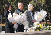 Toshiyuki Mimaki, co-chair of Nihon Hidankyo, and others lay flowers at the A-bomb victim cenotaph in Hiroshima Peace Memorial Park in the city of Hiroshima on Wednesday to report the receipt of this year's Nobel Peace Prize.