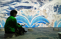 Illustrations of waves taken from ukiyo-e works are displayed on the wall and floor at an installation in the 