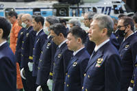 Japan Coast Guard personnel and others offer prayers at a memorial ceremony held at a facility on the premises of Tokyo's Haneda Airport on Monday, ahead of the first anniversary of the Jan. 2 fatal collision between a JCG aircraft and a Japan Airlines plane.