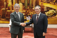 Japanese Foreign Minister Takeshi Iwaya (left) shakes hands with Chinese Premier Li Qiang at the Great Hall of the People in Beijing on Wednesday. (Pool photo)