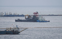 A work vessel drops sand on the seabed during ground improvement work off the coast of Henoko in Okinawa Prefecture on Saturday.