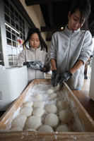 A woman (right) volunteers to prepare food in the city of Suzu, Ishikawa Prefecture, on New Year's Eve on Tuesday.