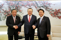 LDP Secretary-General Hiroshi Moriyama (left) and Makoto Nishida, secretary-general of Komeito (right), shake hands with Liu Jianchao, head of the CPC Central Committee's International Department (center), in Beijing, China, on Tuesday. (Pool photo)