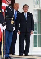 Japanese Prime Minister Shigeru Ishiba (right) is welcomed by U.S. President Donald Trump upon his arrival at the White House in Washington on Friday.