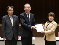 Japanese education minister Toshiko Abe (right) receives a package of proposals about university education from an advisory panel in Tokyo on Friday.