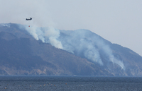 Smoke rises from the mountainside due to the forest fire in the city of Ofunato, Iwate Prefecture, on Friday.