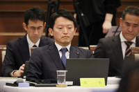 Hyogo Governor Motohiko Saito listens to a report read by Kenichi Okutani, chairman of a special investigative committee, in a plenary session of the Hyogo prefectural assembly in Kobe on Wednesday.