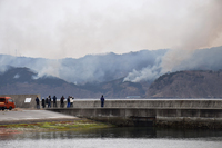 People watch the forest fire from a fishing port in Ofunato, Iwate Prefecture, on Monday.