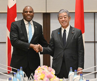 Japanese Foreign Minister Takeshi Iwaya (right) and his British counterpart, David Lammy, shake hands ahead of their meeting in Tokyo on Friday. (Pool photo)