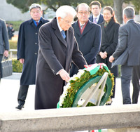 Italian President Sergio Mattarella (foreground) lays flowers at the cenotaph for atomic bomb victims in Hiroshima Peace Memorial Park on Saturday.