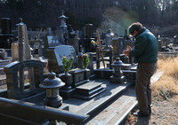 Shoichi Owada prays at the grave of his sister who died in the March 2011 disaster, in Rikuzentakata, Iwate Prefecture, on Tuesday.