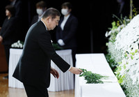 Japanese Prime Minister Shigeru Ishiba lays flowers at a memorial ceremony for the 2011 disaster held in the city of Fukushima on Tuesday. (Pool photo)