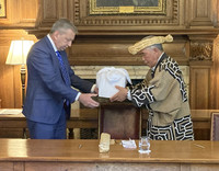 Masaru Okawa (right), head of the Ainu Association of Hokkaido, receives the remains of three Ainu people from Peter Mathieson, principal of the University of Edinburgh, at a ceremony held at the school in the Scottish city on Wednesday.