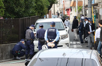 Police officers and others examine the car believed to have hit children in Osaka on Thursday.