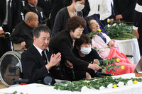 People offer flowers in a memorial ceremony for Minamata disease victims in Minamata, Kumamoto Prefecture, southwestern Japan, on Thursday.