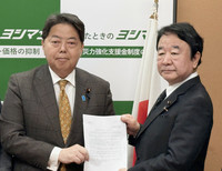 Chief Cabinet Secretary Yoshimasa Hayashi (left) receives a request from Shigeharu Aoyama, head of a group of conservative LDP lawmakers on Wednesday.