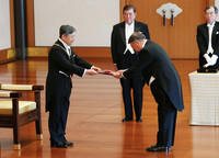 Emperor Naruhito hands the Grand Cordon of the Order of the Paulownia Flowers to ex-House of Representatives Speaker Tadamori Oshima in the Matsu-no-Ma room of the Imperial Palace in Tokyo on Friday.