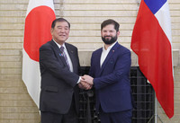 Japanese Prime Minister Shigeru Ishiba (left) and Chilean President Gabriel Boric shake hands at the prime minister's official residence in Tokyo on Sunday. (Pool photo)
