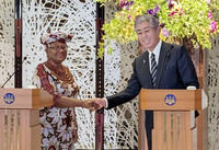 WTO Director-General Ngozi Okonjo-Iweala (left) and Japanese Foreign Minister Takeshi Iwaya shake hands at a press conference in Tokyo on Tuesday.