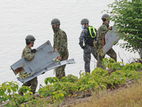Apparent parts of the crashed ASDF plane are recovered around Lake Iruka in Inuyama, Aichi Prefecture, on Thursday.
