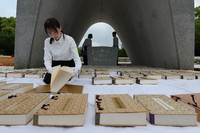 Hiroshima city officials air out the register of A-bomb victims at Hiroshima Peace Memorial Park on Thursday.