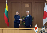 Japanese Defense Minister Gen Nakatani (right) and Lithuanian Defense Minister Dovile Sakaliene shake hands at the Ministry of Defense in Tokyo on Wednesday.