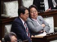 Economic revitalization Minister Ryosei Akazawa (left) chats with Chief Cabinet Secretary Yoshimasa Hayashi in the House of Representatives on Thursday.