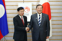Japanese Prime Minister Shigeru Ishiba (right) shakes hands with Laotian President Thongloun Sisoulith (left) on Thursday.