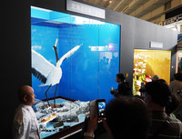 Visitors view a confectionery piece shaped like a red-crowned crane at the Asahikawa confectionery exposition in Hokkaido on Friday.