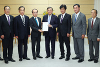 Prime Minister Shigeru Ishiba (center) receives a written request from Okuma Mayor Jun Yoshida (third from left) at the prime minister's office on Wednesday.