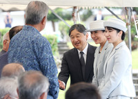 Emperor Naruhito, Empress Masako and their daughter, Princess Aiko, speak with bereaved families after offering flowers at the National War Dead Peace Mausoleum in the Peace Memorial Park in Itoman, Okinawa Prefecture, on Wednesday.