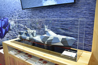 A model of a multipurpose combat-support unmanned surface vehicle under research by Japan's Acquisition, Technology & Logistics Agency is on display at the Makuhari Messe convention center in the city of Chiba, near Tokyo, on May 23. The agency is aiming to equip the USV with artificial intelligence and the ability to launch antiship missiles and torpedoes.
