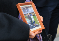Masako Akagi speaks to reporters in front of Osaka High Court on Jan. 30 showing a photo with her husband, Toshio, who was a Finance Ministry official and committed suicide after being forced to tamper with