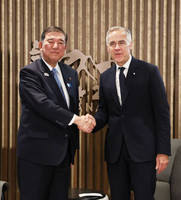 Japanese Prime Minister Shigeru Ishiba (left) and his Canadian counterpart, Mark Carney, shake hands before their summit in Kananaskis, Canada, on Monday. (Pool photo)