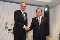 Japanese Prime Minister Shigeru Ishiba (right) and German Chancellor Friedrich Merz shake hands just before holding bilateral talks in Kananaskis, western Canada, Monday on the fringe of a two-day Group of Seven summit through Tuesday.