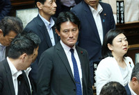 Tatsunori Ibayashi of the Liberal Democratic Party (center) shows a stern look at the Diet Building in Tokyo on Wednesday following the passage of a motion to dismiss him as chairman of the House of Representatives Financial Affairs Committee.