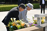 Emperor Naruhito and Empress Masako offer flowers at the cenotaph for atomic bomb victims at Hiroshima's Peace Memorial Park on Thursday.