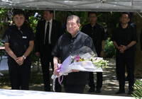 Prime Minister Shigeru Ishiba (center) lays flowers at a monument for the Himeyuri corps in the city of Itoman, Okinawa Prefecture, on Monday. (Pool photo)