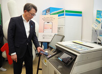 Digital Transformation Minister Masaaki Taira obtains a certificate using an iPhone equipped with My Number card functions in Tokyo on Tuesday.
