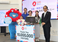 Kazuhiro Asano (fourth from right) receives commemorative gifts with his family as the 10 millionth visitor to the Osaka Expo in Osaka on Sunday.