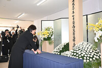 Kurashiki Mayor Kaori Ito offers flowers at a memorial event for the western Japan rain disaster victims in the city of Kurashiki, Okayama Prefecture, on Sunday.