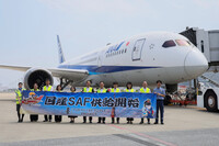 Officials from All Nippon Airways, JGC Holdings and other entities hold a banner in front of an aircraft loaded with sustainable aviation fuel at Haneda Airport in Tokyo on Monday.