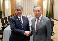 Japanese Foreign Minister Takeshi Iwaya (left) and Chinese Foreign Minister Wang Yi shake hands in Kuala Lumpur on Thursday. (Courtesy of the Japanese Foreign Ministry)