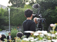 A former company employee who now creates political highlight videos livestreams a stump speech by politician Shinji Ishimaru on YouTube in Tokyo on June 27.