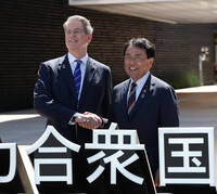 U.S. Treasury Secretary Scott Bessent (left) and Japanese economic revitalization minister Ryosei Akazawa shake hands in front of the U.S. Pavilion at the Osaka Expo on Saturday.