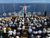 Bereaved families pray for war dead during an at-sea memorial service hosted by Nippon Izokukai off the coast of Luzon Island in the Philippines on June 8. (Courtesy of the organization)