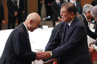 Toshiyuki Mimaki (left), head of a group of hibakusha atomic bomb survivors in Hiroshima Prefecture, shakes hands with Japanese Prime Minister Shigeru Ishiba during a meeting in the city of Hiroshima on Wednesday.