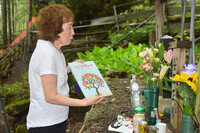 Machiko Taniguchi speaks to her husband's memorial marker in the village of Ueno in Gunma Prefecture on July 16, updating him on a lecture she delivered at JAL the preceding week.