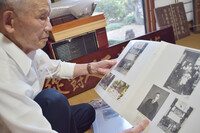 Hiroyoshi Takizawa looks at a photograph from Manchuria during a June interview in Nagano.